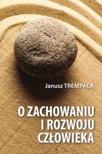 Kamień na zagrabionym piasku i białe litery