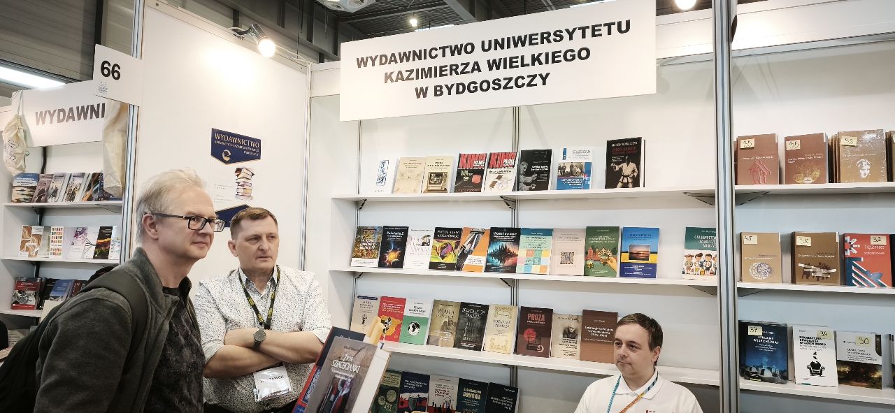 poznan2 Ciemne, brązowe tło, beżowe i czerwone liternictwo, beżowa postać karateki bez twarzy